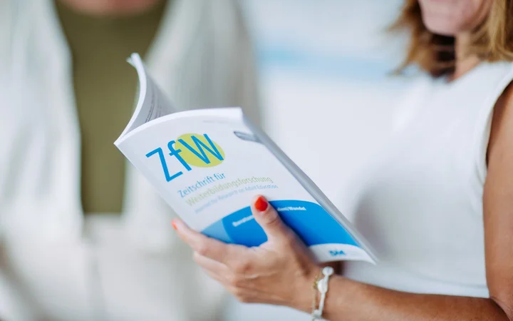 Eine Frau liest in einer Publikation der ZfW
