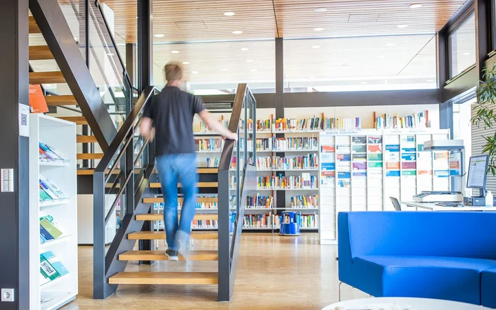 Ein Mann geht die Treppe der Bibliothek hinauf.