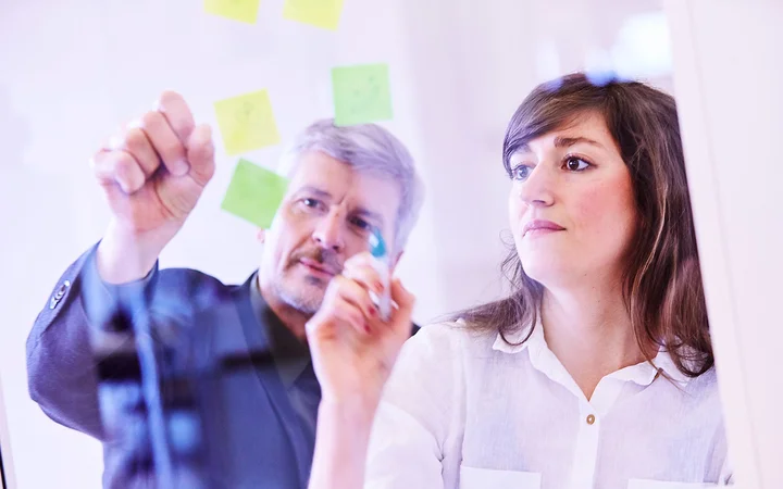 Two people making notes on post-its