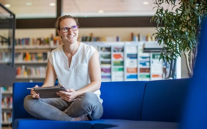 Frau auf einem Sofa in der DIE-Bibliothek