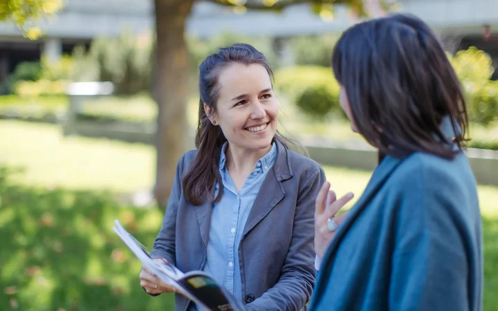 Two women talking about a DIE publication